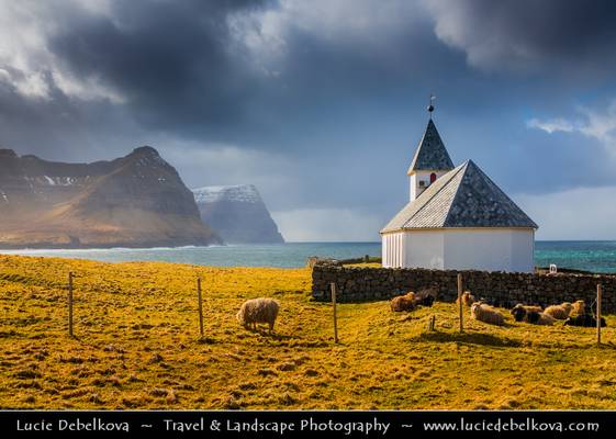 Faroe Islands - Vidoy Island - Classic view of Vidareidi church with cliffs of Bordoy and Kunoy islands