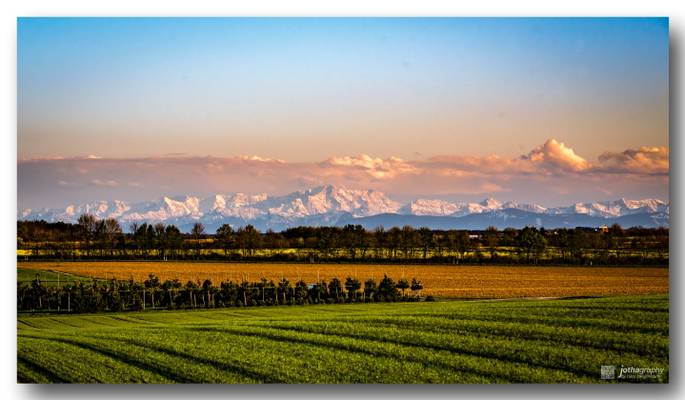 Colorful bands - Snowy alps in spring sunset