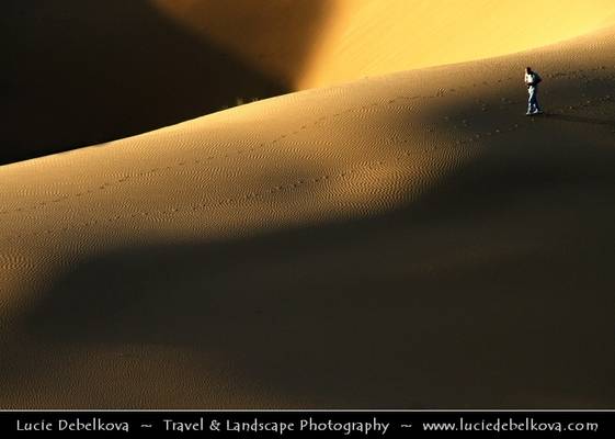 Iran - Lonely photographer in dunes at Maranjob at Dasht-e Kavir Desert