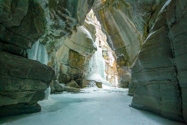 Frozen Maligne river inside canyon walls