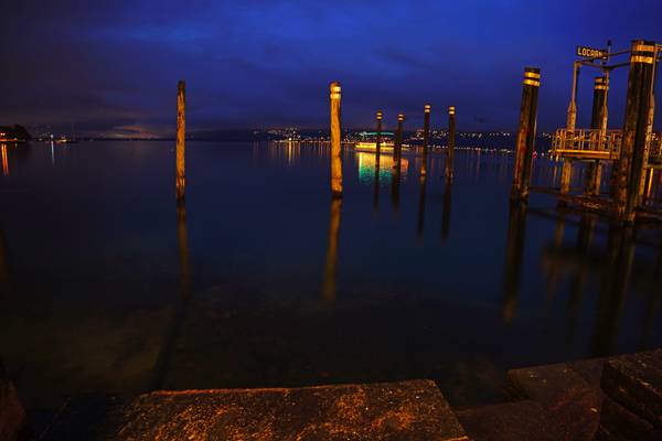 Locarno by night. Wooden poles in the lake