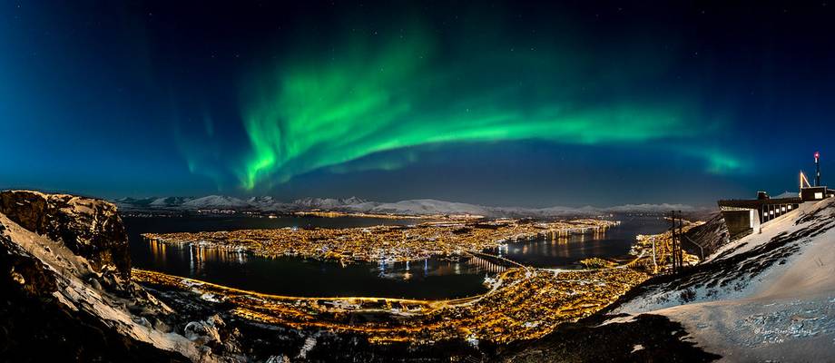 Tromsø i måneskinn under nordlyset