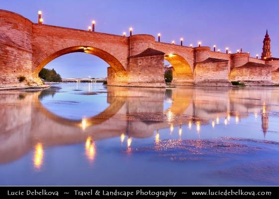 Spain - Aragon - Zaragoza - Puente de Piedra - Stone Bridge over Ebro River lit at Twilight - Dusk - Blue Hour - Night