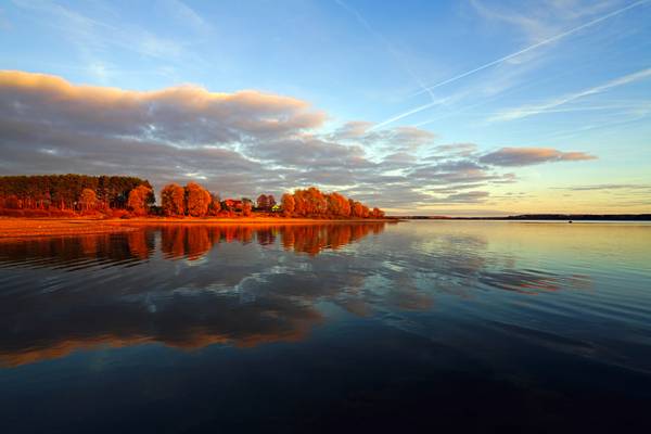 Magnificent reflections in the calm water of Mozhaysk Sea at sunset, Russia