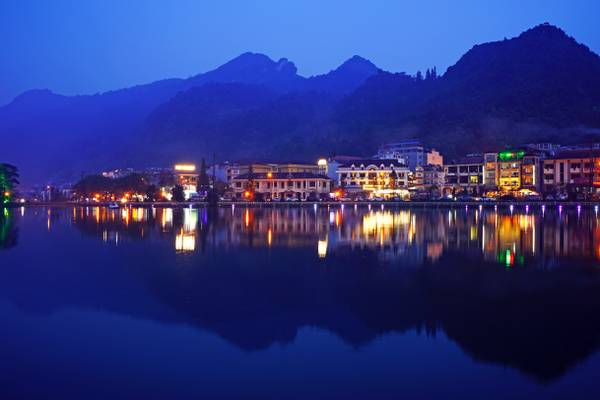 Mountains silhouettes reflecting in Sapa Lake at the blue hour