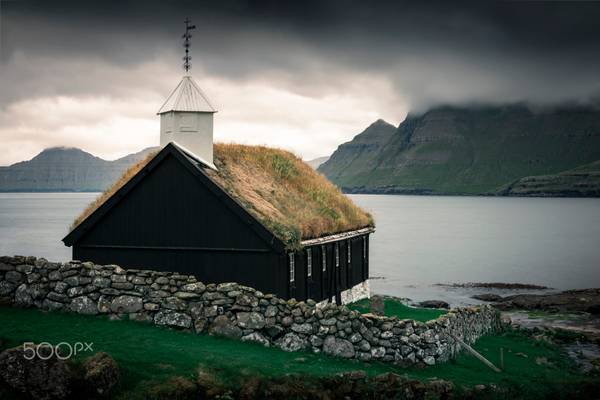 Church of the village Funningur under dramatic clouds, Faroe Islands