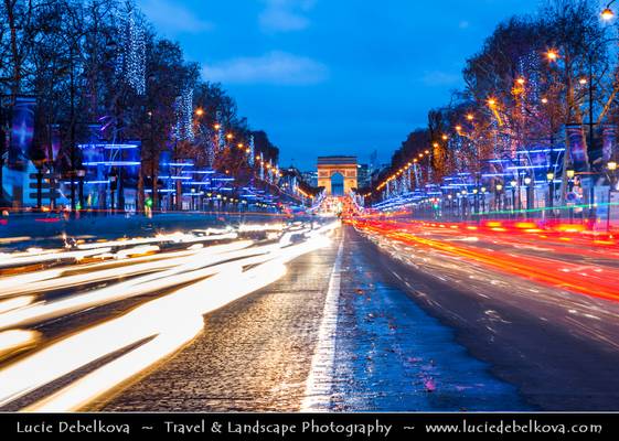 France - Paris - The Arc de Triomphe - Arc de Triomphe de l'Étoile & Avenue des Champs Elysees illuminated with Christmas lights with passing evening traffic