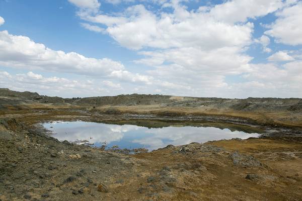 Natural water and oil compound lake in steppe  with bitumen slopes