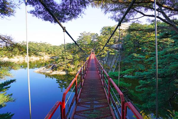 Red suspension bridge over Samilpo lake, North Korea