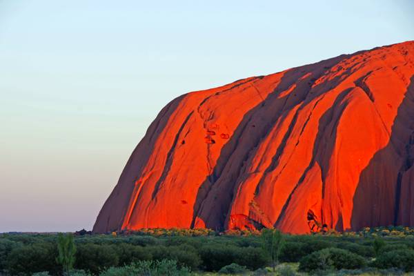 Red wall of Uluru at sunset