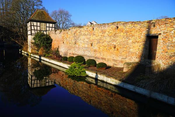 The old red brick wall reflecting in La Lauch, Colmar
