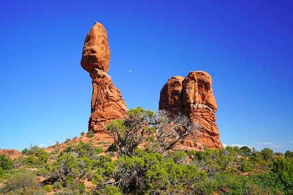The moon behind the Balanced Rock, Arches NP, USA