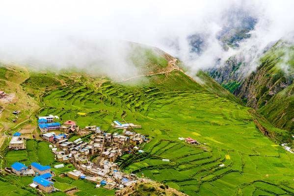 Green terraced fields and traditional architecture in the ancient Tibetan Nar village, Annapurna...