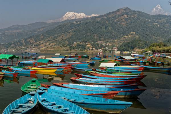 Boats on Lake Phewa, Pokhara with Annapurnas and hang gliders in background